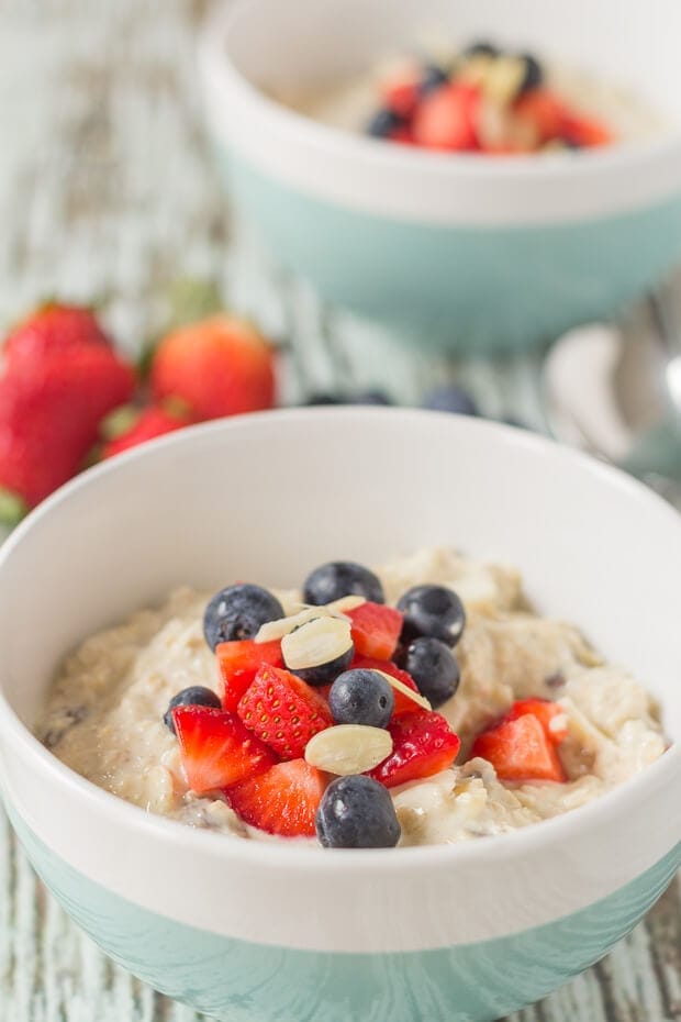 Close up of a bowl of healthy bircher muesli topped with chopped strawberries, blueberries and flaked almonds.y version of the classic overnight oats recipe providing the perfect relaxing and healthy start to the day!
