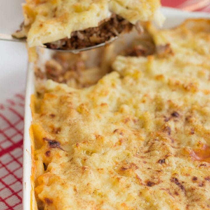 Healthier Greek Pastitsio with a portion being lifted out on a spoon.