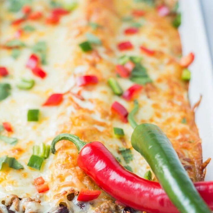 Cooked meat free quorn enchiladas in a casserole dish covered in melted cheese.