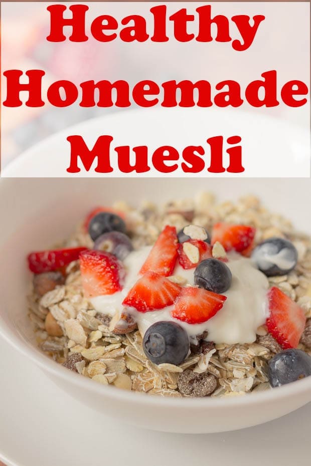 A bowl of healthy homemade muesli served with greek yogurt and chopped strawberries and blueberries.