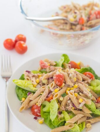 A plate of tuna and sweetcorn pasta salad with a bowl of the remainder of the pasta salad at the top.
