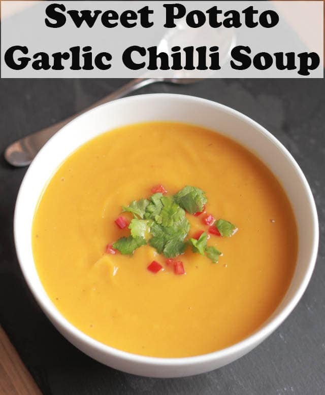 A bowl of sweet potato garlic and chilli soup garnished with coriander and chopped red pepper. Pin title text overlay at top.
