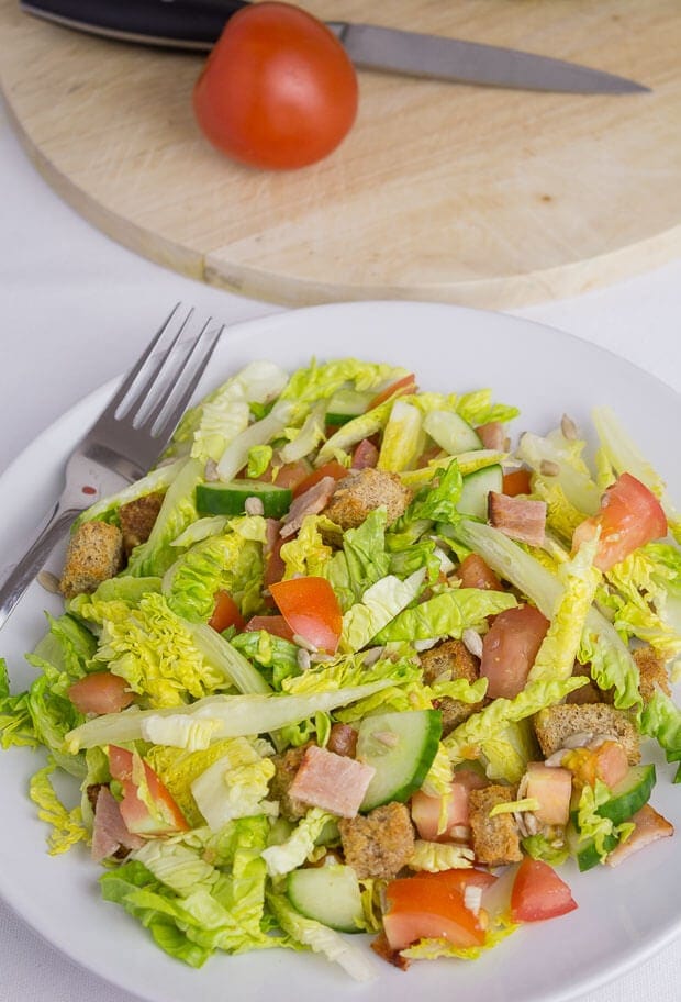 Close up of a plate of turkey bacon and tomato salad.