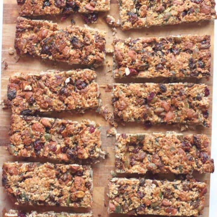 12 fruit and nut snack bars cut up on a chopping board.