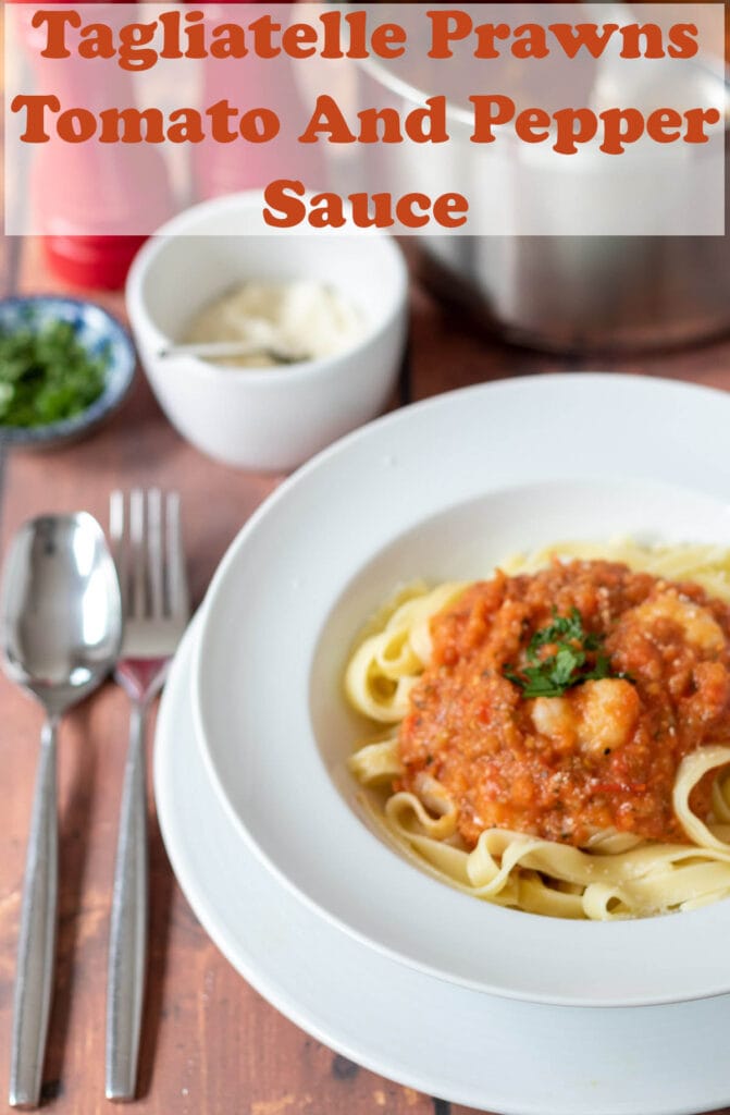 Chilli prawn tagliatelle served in a white pasta bowl with a knife and fork to the side. Pin title text overlay at top.