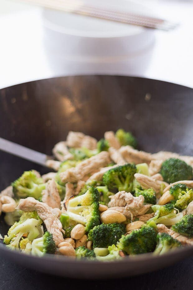 A wok with cooked turkey and broccoli stir fry in. Serving spoon at the back.