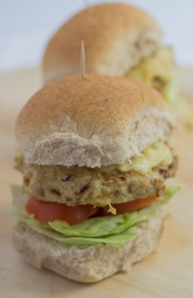 Close up of a turkey burger on a wholemeal bun garnished with lettuce and tomtato slices.