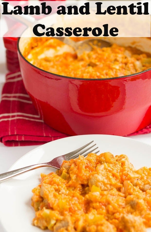 A plate of lamb and lentil casserole at the front with the casserole pot of the remaining lentil stew in the background.