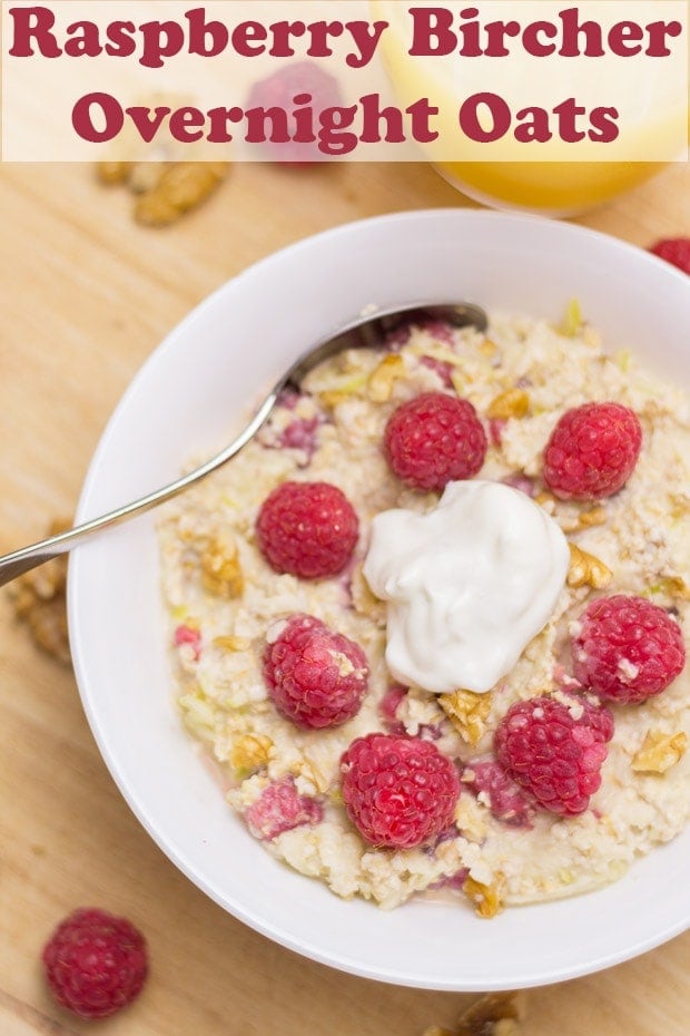 Birds eye view of a bowl of raspberry bircher overnight oats decoated with raspberries and a dollup of Greek yogurt in the middle. Pin title text overlay at top.
