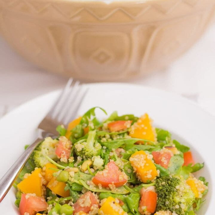 A plate of summer superfood salad with the rest in a large bowl in the background.