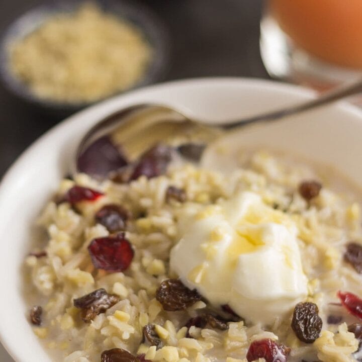 Bowl of overnight breakfast rice pudding topped with nuts and seeds and yogurt.