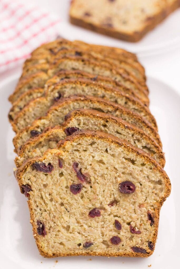 Cranberry banana bread sliced on a serving dish.