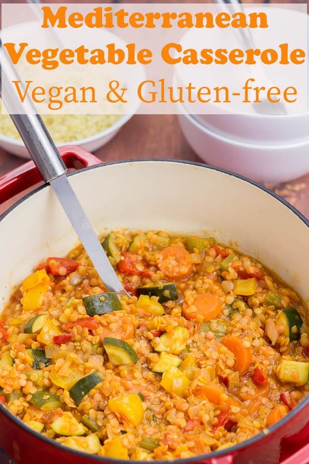 Casserole pot of mediterranean vegetable casserole with a spoon in it ready to serve.