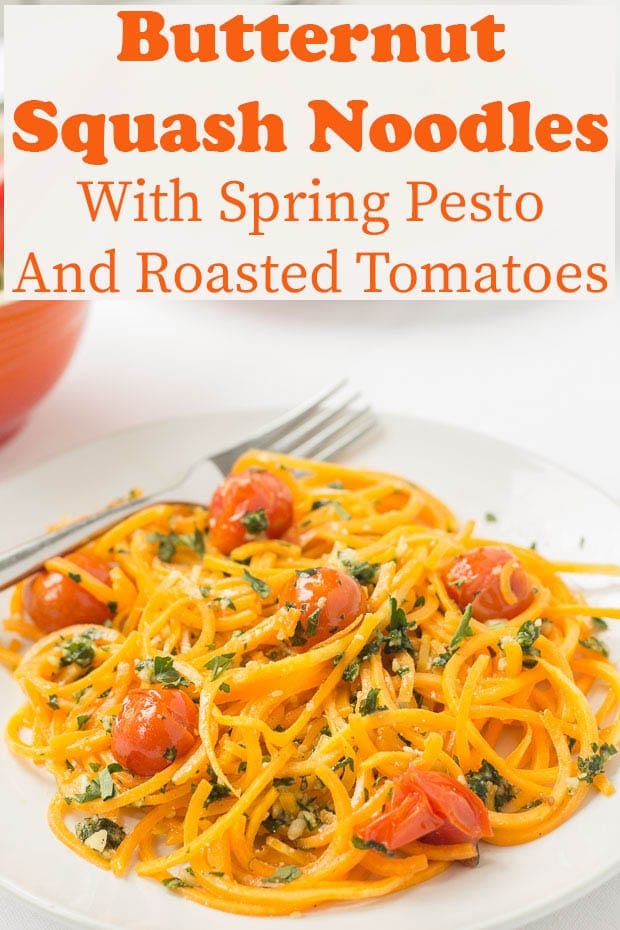 A plate of butternut squash noodles with spring pesto and roasted tomotoes ready to eat.