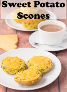 A plate of sweet potato scones halved with melted cheese on and a cup of tea. Pin title text overlay at top.