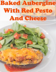 Half a baked aubergine with red pesto and cheese on a dinner plate with salad. Pin title text overlay at top.