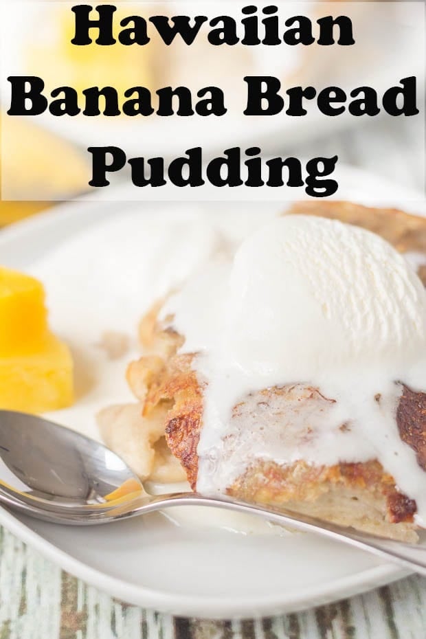 A portion of Hawaiian Banana Bread Pudding on a plate with ice cream melting over the top and served with a few pineapple chunks to the side.
