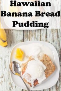 Birds eye view of a plate of Hawaiian banana bread pudding with a dollup of ice cream melting over the top. Dessert spoon and pineapple chunks to the side. Pin title text overlay at top.