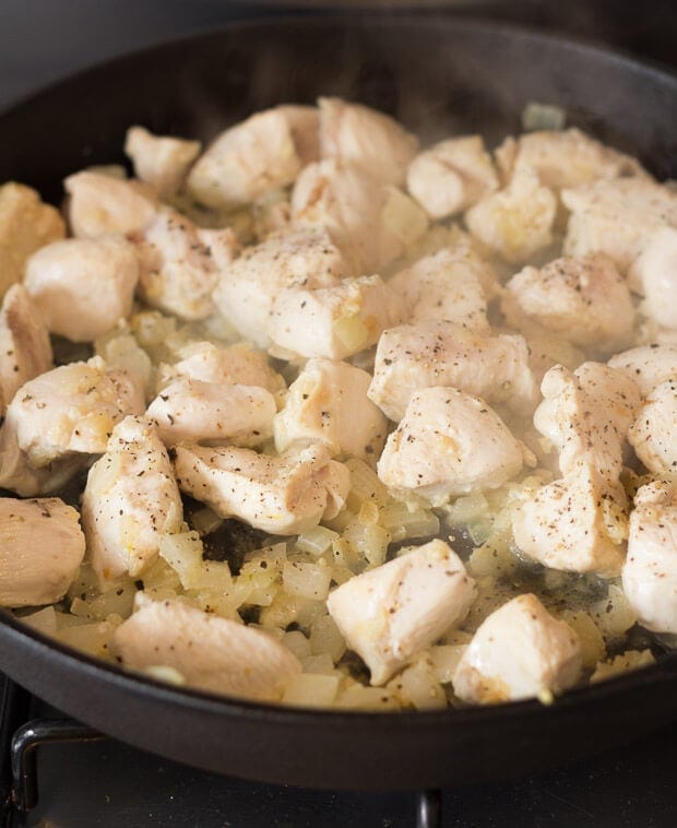 Chicken being cooked in a skillet.