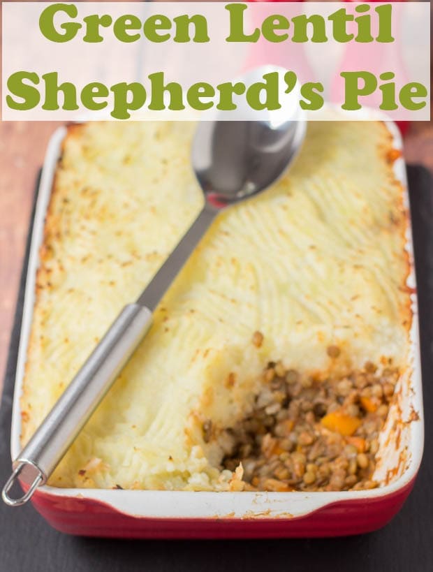 Green lentil shepherds pie just taken out of the oven with a portions taken out of it and a spoon layed over it.