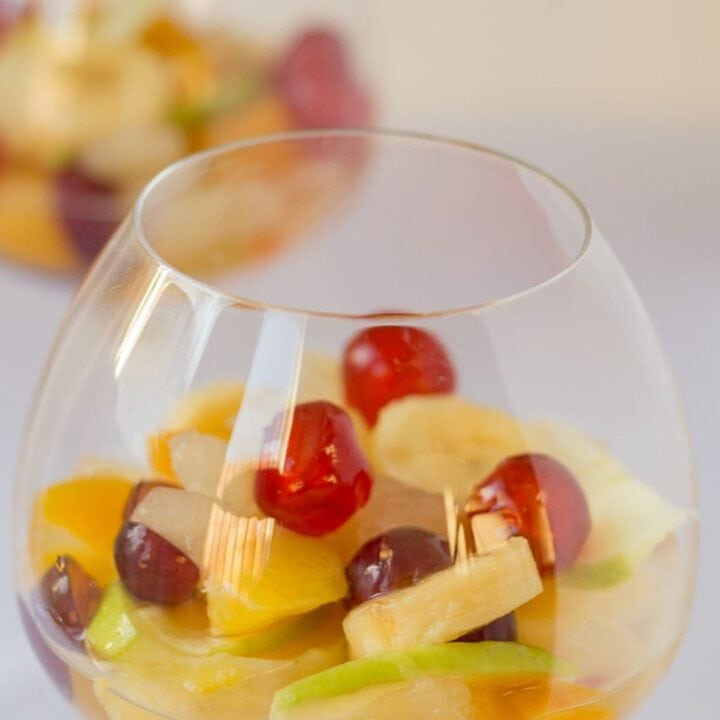 Two glasses of boozy fruit salad one in front of the other.