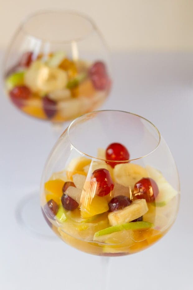 Close up view of two glasses of boozy fruit salad.