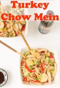 Birds eye view of two bowls of turkey chow mein with chopsticks in.