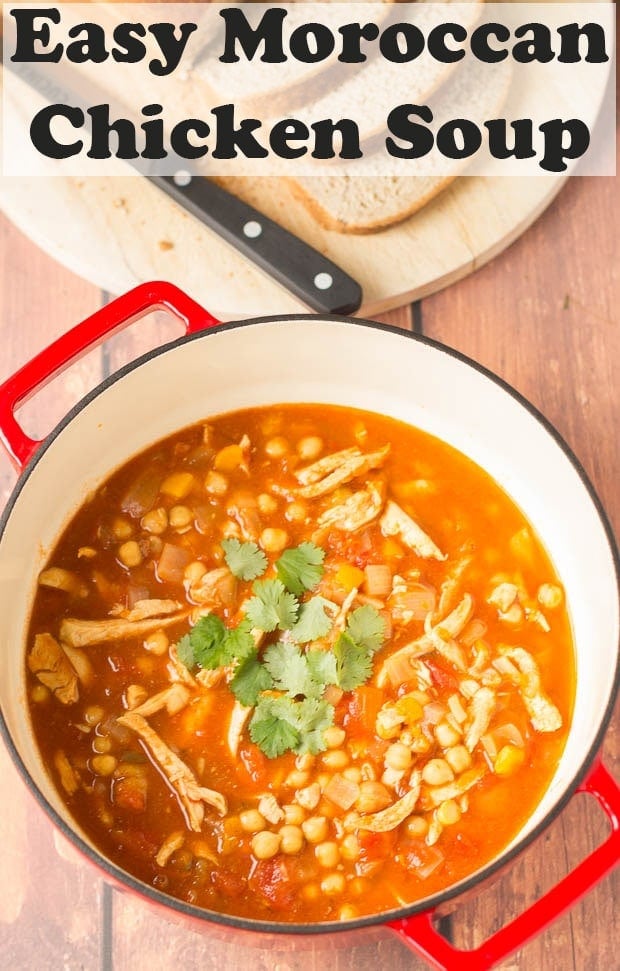 Close up of a pot of easy Moroccan chicken soup garnished with chopped coriander. Slices of bread and a carving knife on a bread board at the top.