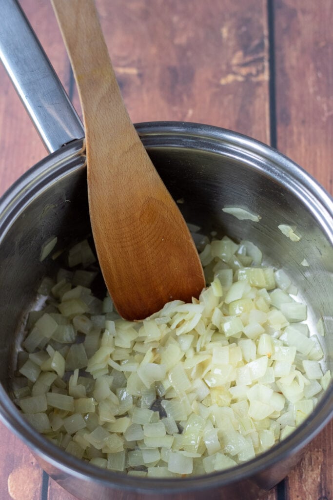Diced onion being sauted until soft in a large saucepan.
