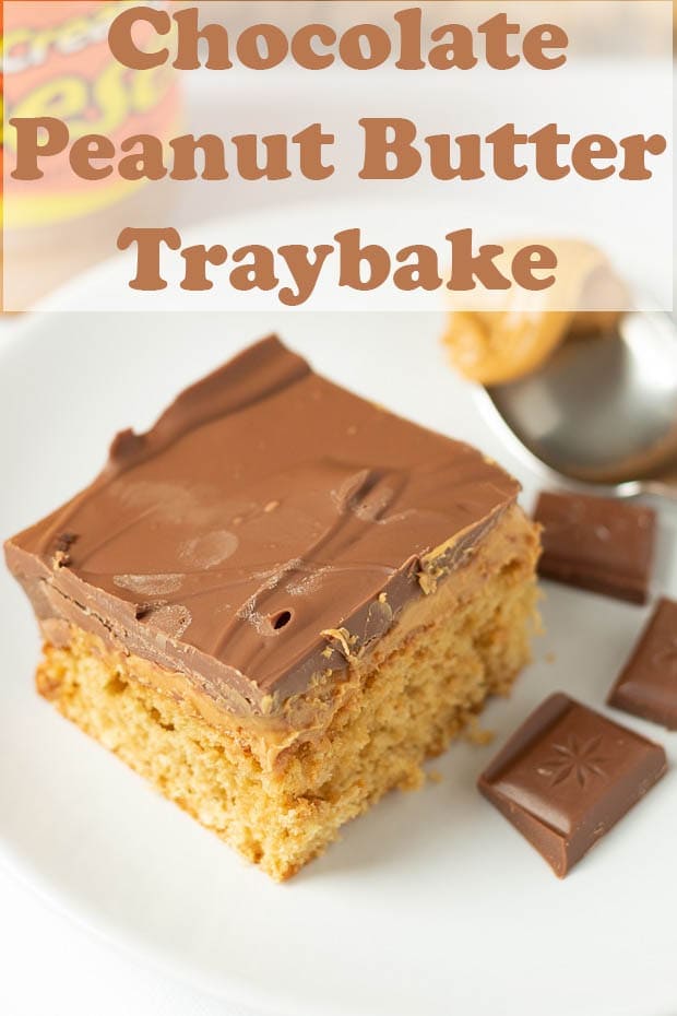 A slice of chocolate peanut butter traybake on a plate with a teaspoon of peanut butter and squares of chocolate around as decorations.