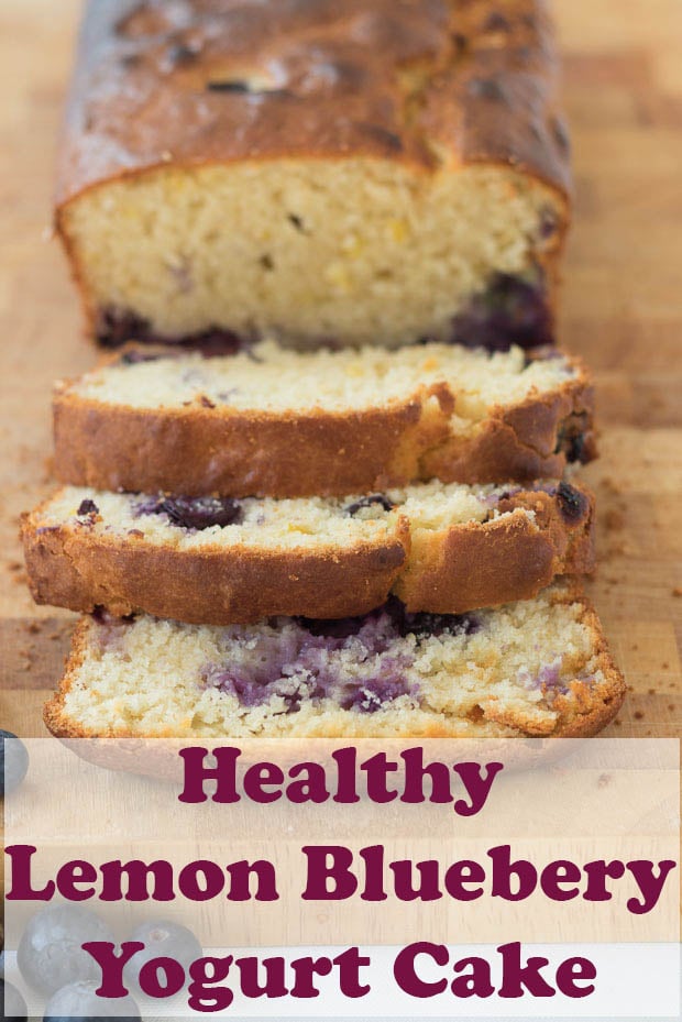 Lemon blueberry yogurt cake sliced and facing forward on a wooden bread board.