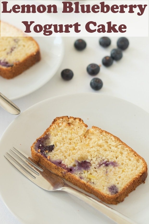 A slice of lemon blueberry cake served on a plate with a fork to the side. Blueberries scattered around. Pin title text overlay at top.