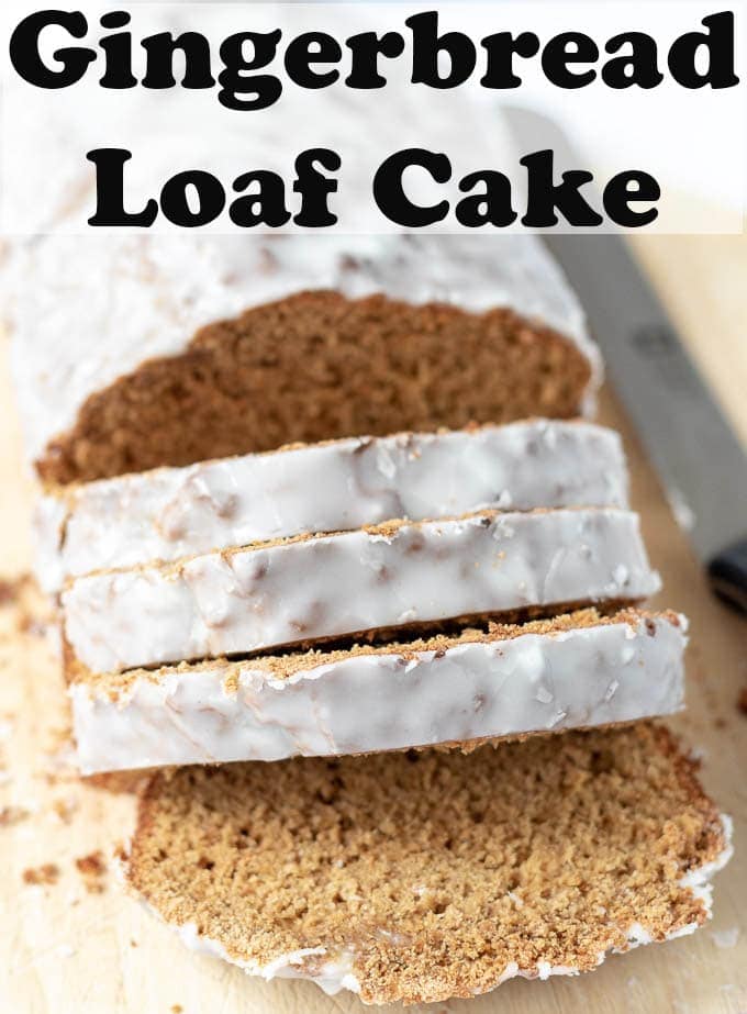 Close up of gingerbread loaf cake on a chopping board facing forward with 4 slices cut off.