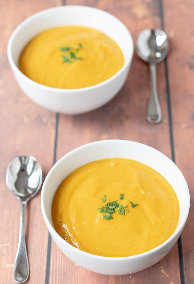 Front view of two bowls of delicious and filling sweet potato and red lentil soup served and ready to eat.