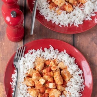 Birds eye view of two delicious plates of Mediterranean feta chicken served on a bed of bismati rice.