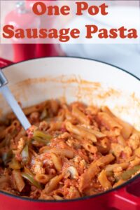 One pot sausage pasta with a serving spoon in it. Pin title text overlay at top.