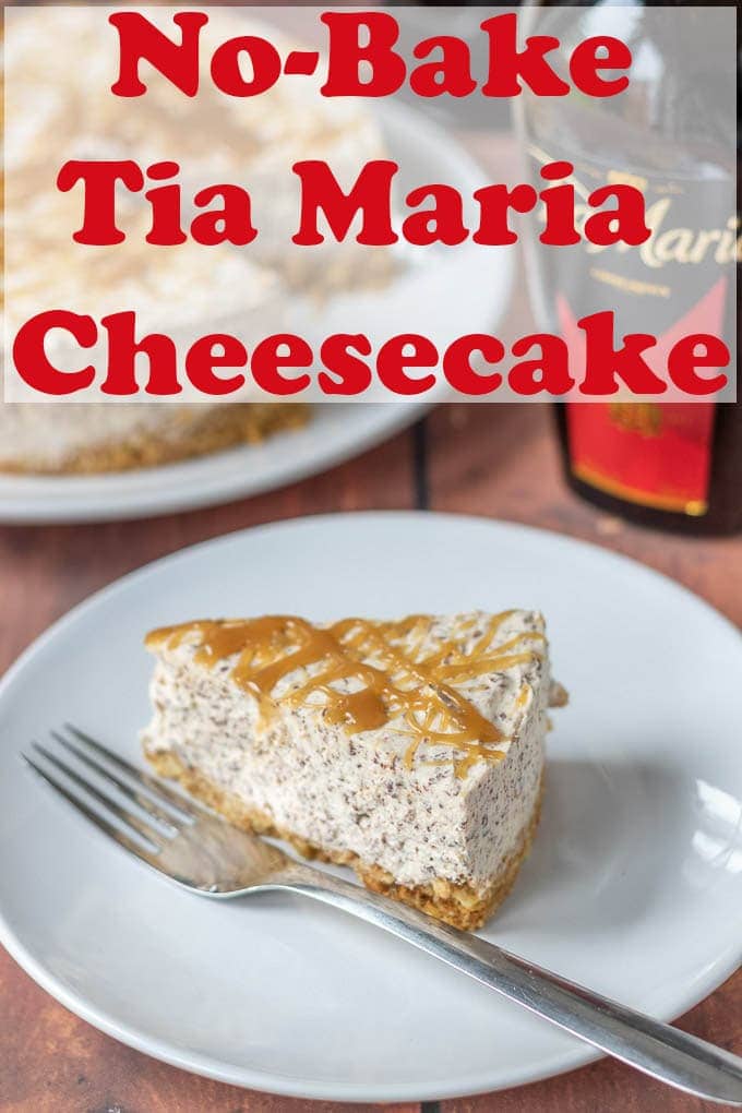 A slice of Tia Maria cheesecake on a plate with a bottle of Tia Maria and the rest of the cheesecake in the background.