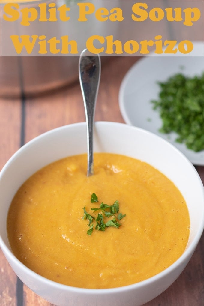 A bowl of chorizo yellow split pea soup garnished with chopped coriander and a spoon in. Pin title text overlay at top.
