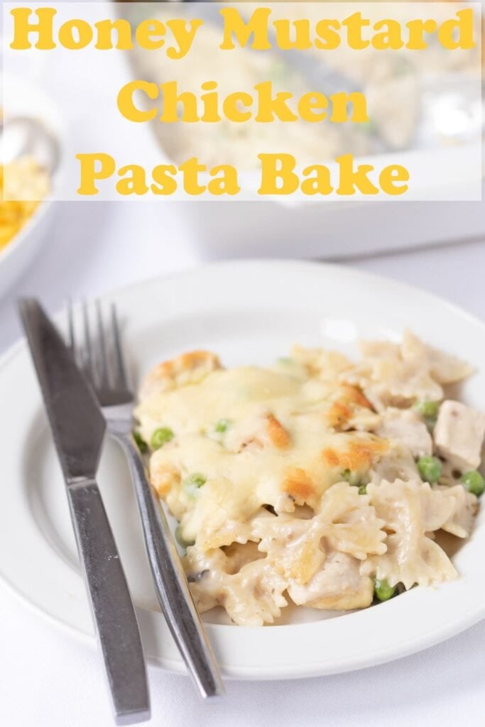 A portion of honey mustard chicken pasta bake served on a plate with a knife and fork to the left hand side. Pin title text overlay at top.