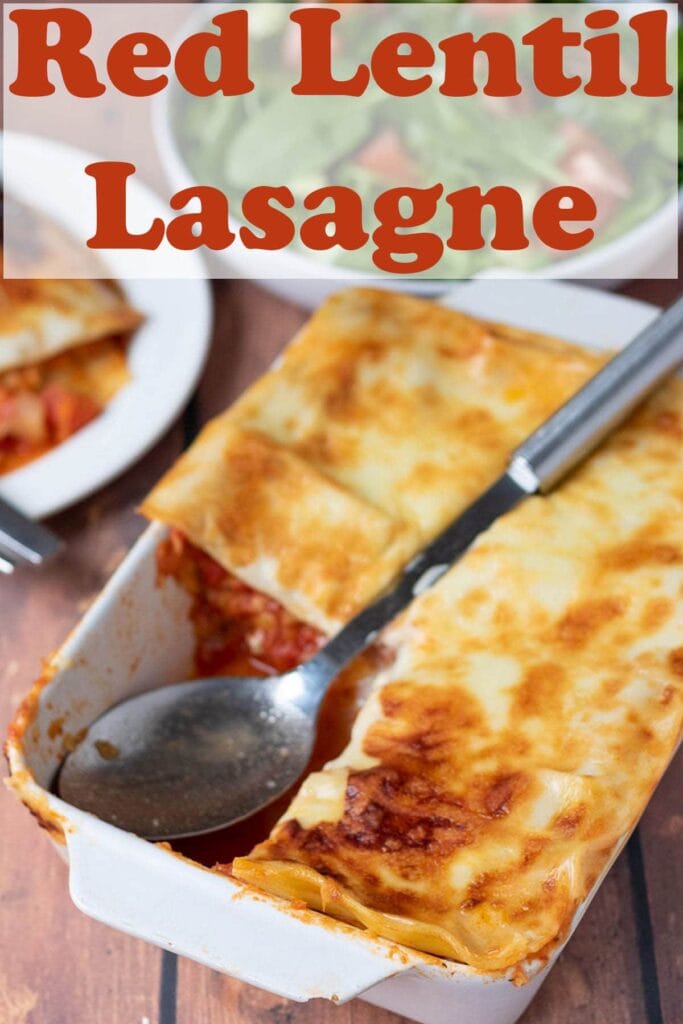 Red lentil lasagne in a dish with a portion taken out of it and Pin title at the top.
