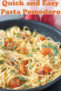 A large pan of cooked pasta pomodoro. Pin title text overlay at top.