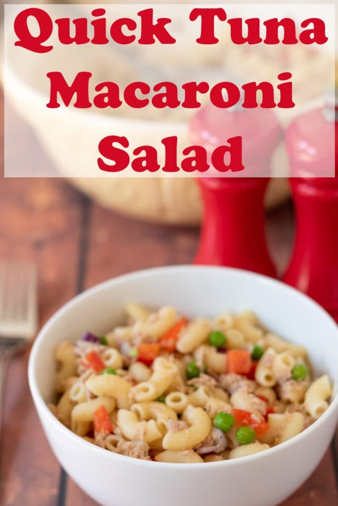 A bowl of tuna macaroni salad. Salt and pepper cellars alongside. Pin title text overlay at top.