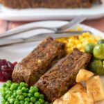 Festive nut roast served with roast potatoes, peas, sprouts, sweetcorn and cranberry sauce.