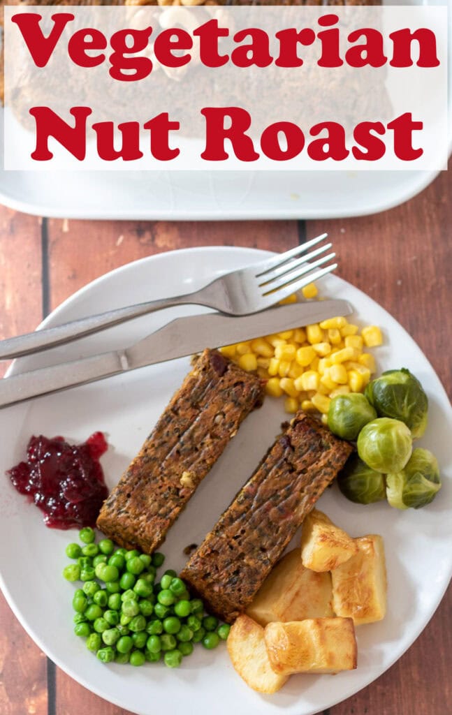 A plate with two slices of vegetarian nut roast on surrounded by roast potatoes, peas, brussels sprouts, sweetcorn and cranberry sauce with a knife and fork at the side. Pin title text overlay at top.
