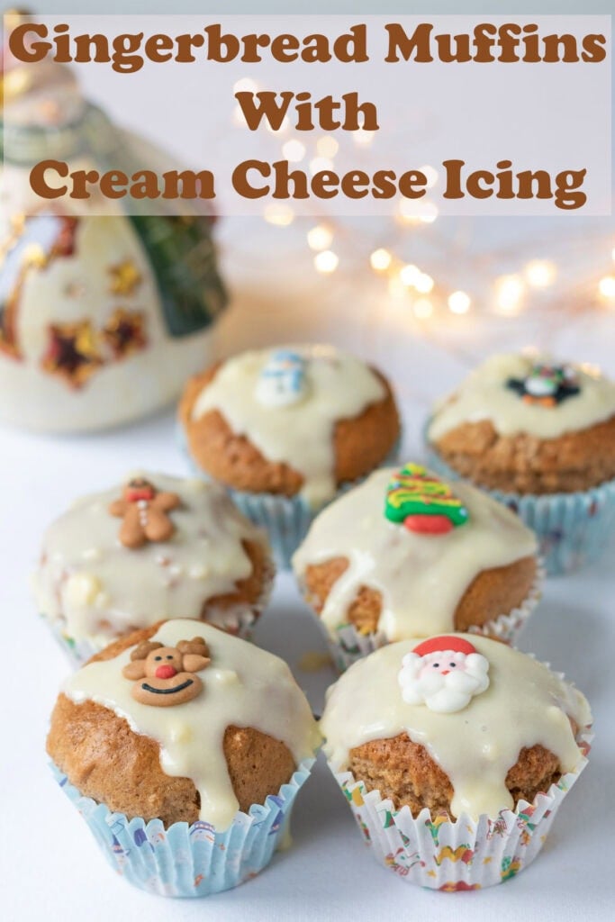 Six gingerbread muffins with cream cheese icing laid out on a table. Pin title text overlay at top.