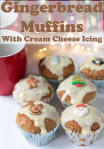 Six gingerbread muffins with cream cheese icing with a red cup beside. Pin title text overlay at top.