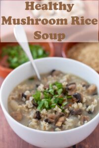 A bowl of mushroom and rice soup garnished with chopped parsley with a soup spoon in. Pin title text overlay at top.