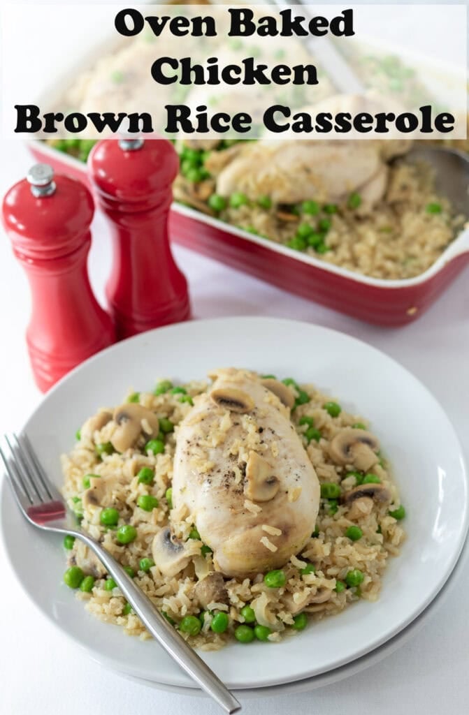 Oven baked chicken and brown rice casserole. Chicken served on the brown rice on a plate with a fork to the left side. Salt and pepper cerrars and rest of chicken in casserole dish in the background. Pin title text overlay at top.