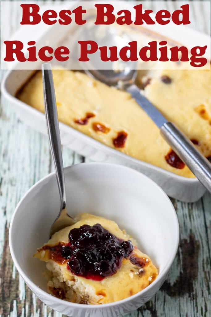 A bowl of baked rice pudding with a dollop of jam on top and a spoon in underneath the casserole dish of the recipe. Pin title text overlay at top.