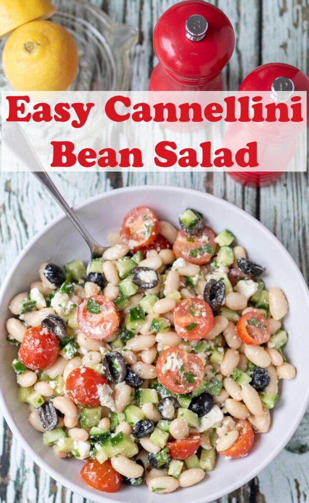 Overhead view of a bowl of cannellini bean salad. Above lemons and salt and pepper cellars. Pin title text overlay at top.
